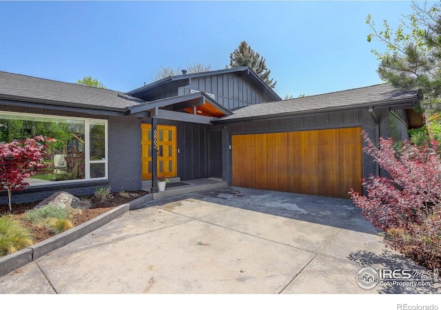 6862 Roaring Fork Trl, Boulder, CO 80301 - view of front facade with an attached garage, concrete driveway, board and batten siding, and brick siding