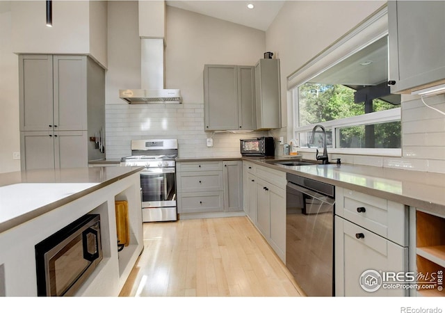 6862 Roaring Fork Trl, Boulder, CO 80301 - kitchen featuring stainless steel appliances, a sink, island range hood, light wood finished floors, and backsplash