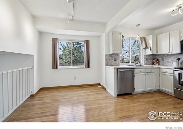 710 Sedge Way, Lafayette, CO 80026 - kitchen with appliances with stainless steel finishes, decorative backsplash, light countertops, light wood-style floors, and white cabinetry