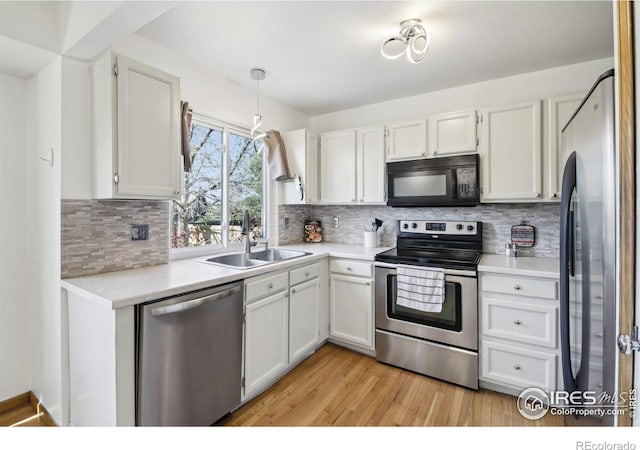 710 Sedge Way, Lafayette, CO 80026 - kitchen featuring stainless steel appliances, light countertops, light wood-style flooring, tasteful backsplash, and white cabinets