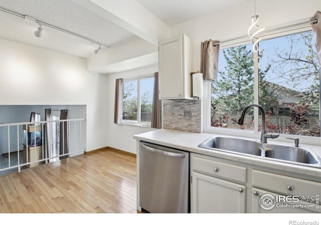 710 Sedge Way, Lafayette, CO 80026 - kitchen featuring stainless steel dishwasher, rail lighting, white cabinets, tasteful backsplash, and light countertops