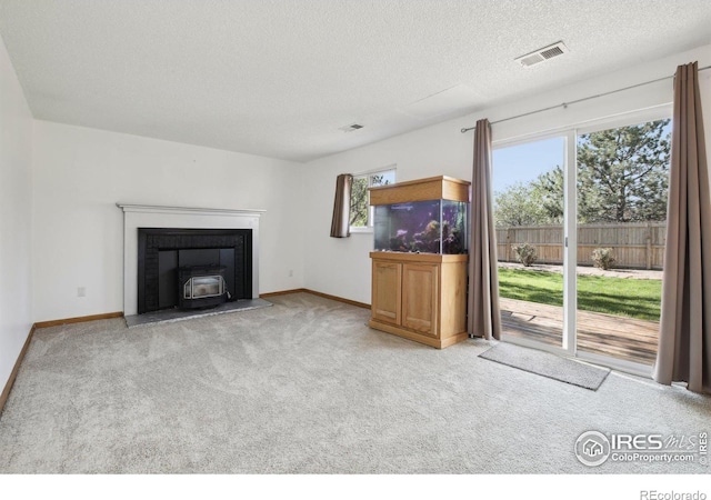 710 Sedge Way, Lafayette, CO 80026 - unfurnished living room with carpet floors, a wood stove, and a textured ceiling