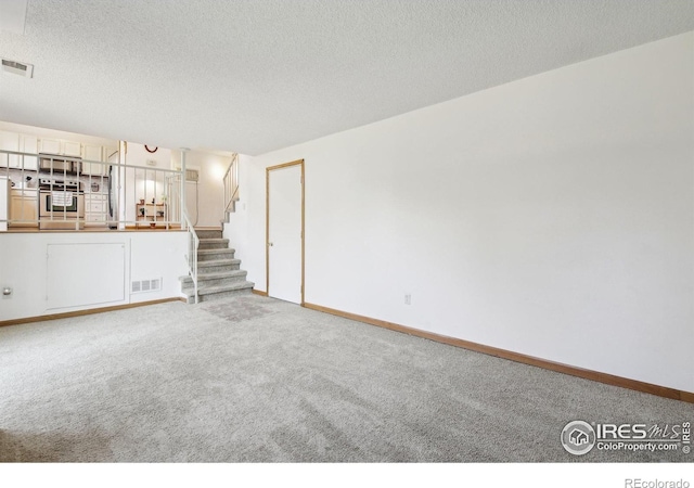 710 Sedge Way, Lafayette, CO 80026 - unfurnished living room with carpet flooring, stairs, and a textured ceiling