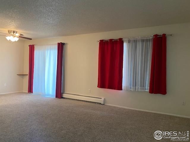 carpeted spare room featuring a baseboard radiator, ceiling fan, a textured ceiling, and baseboards