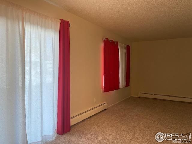 spare room with a baseboard heating unit, carpet floors, a textured ceiling, and a baseboard radiator