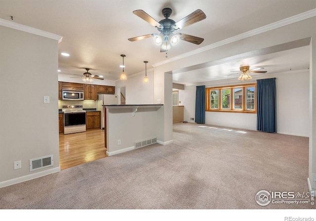 kitchen with white appliances, open floor plan, light colored carpet, brown cabinets, and crown molding