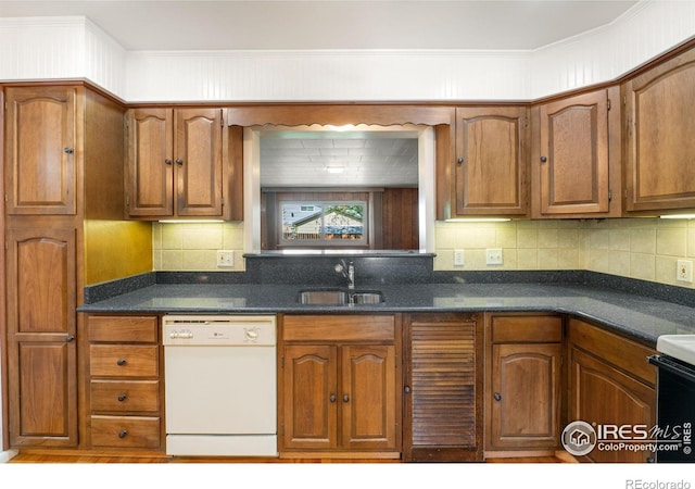 kitchen with white dishwasher, dark countertops, a sink, and brown cabinets