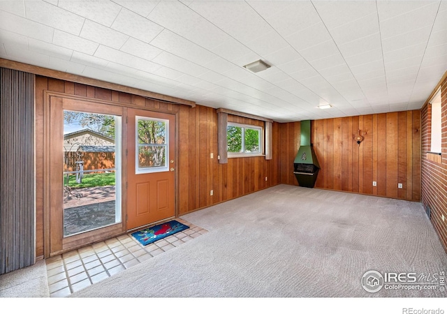 entrance foyer with wooden walls and carpet