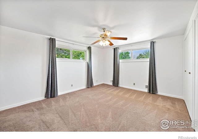 unfurnished room with carpet flooring, ceiling fan, and plenty of natural light