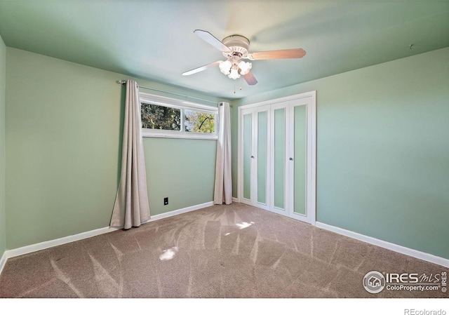 unfurnished bedroom featuring carpet flooring, baseboards, and a ceiling fan