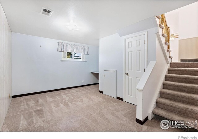 staircase featuring carpet flooring and baseboards