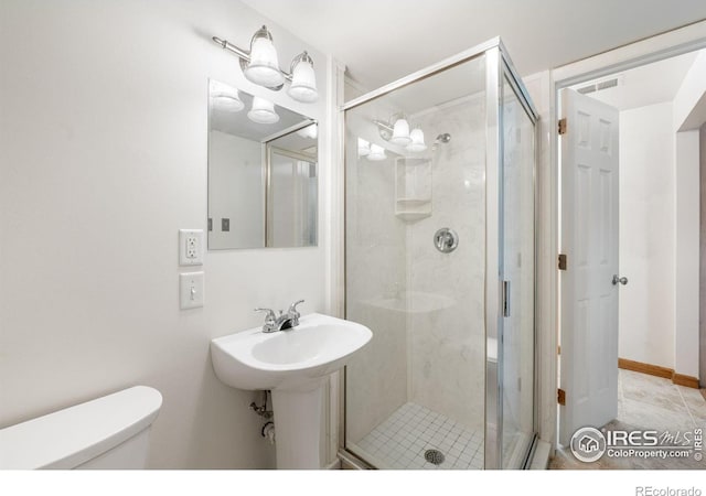 bathroom with toilet and a stall shower