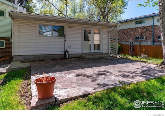 rear view of house featuring a patio and fence