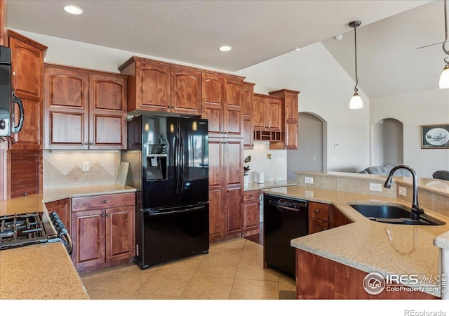 109 Veronica Dr, Windsor, CO 80550 - kitchen with black appliances, a sink, arched walkways, decorative light fixtures, and decorative backsplash