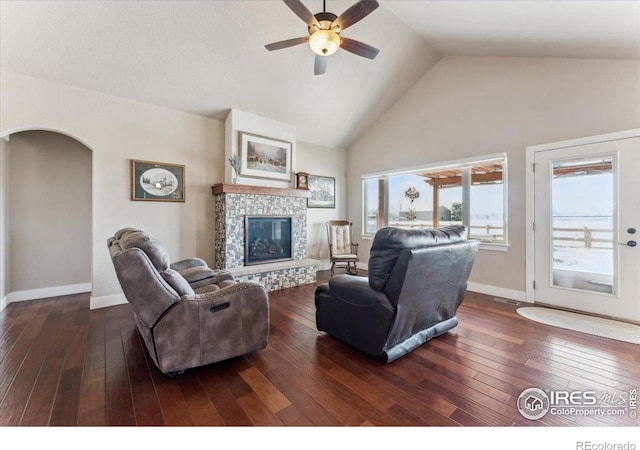 109 Veronica Dr, Windsor, CO 80550 - living area featuring a ceiling fan, high vaulted ceiling, a fireplace, dark wood-type flooring, and arched walkways