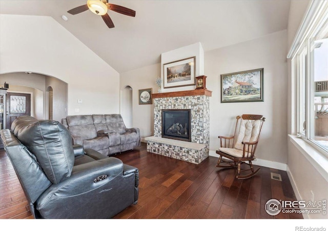 109 Veronica Dr, Windsor, CO 80550 - living room with arched walkways, ceiling fan, vaulted ceiling, hardwood / wood-style floors, and a stone fireplace