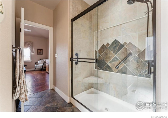 109 Veronica Dr, Windsor, CO 80550 - full bathroom with a stall shower, baseboards, ensuite bathroom, and stone finish flooring