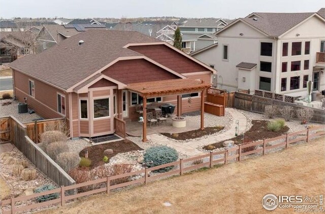 109 Veronica Dr, Windsor, CO 80550 - rear view of property featuring a patio area, a fenced backyard, and a shingled roof