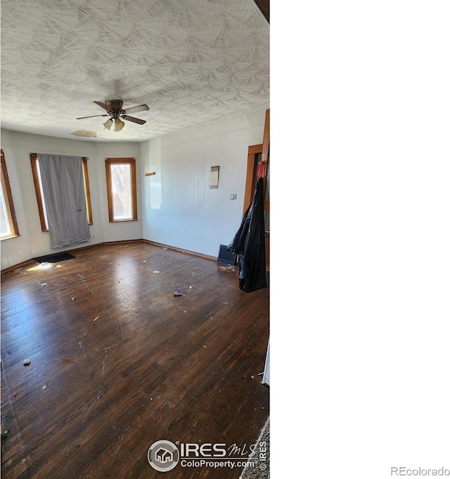 unfurnished living room featuring hardwood / wood-style floors, a ceiling fan, a textured ceiling, and baseboards