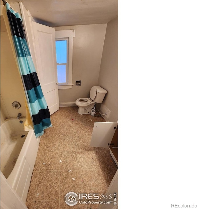 full bathroom with toilet, shower / bathtub combination with curtain, and baseboards