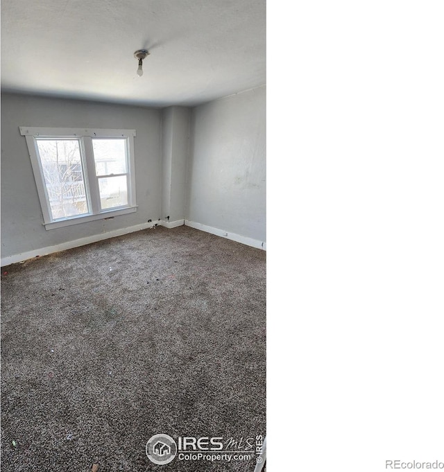 empty room featuring carpet flooring and baseboards