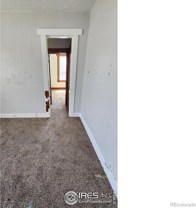 hallway with carpet floors and baseboards