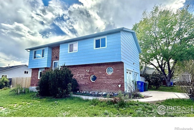 split foyer home featuring concrete driveway, brick siding, and an attached garage