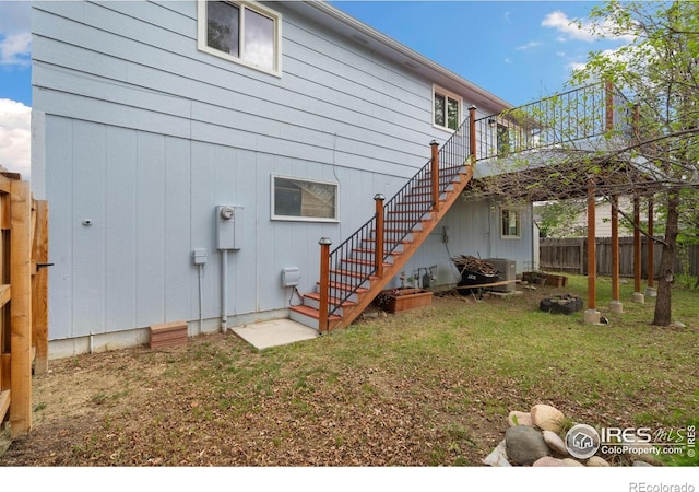 rear view of house featuring stairway and a deck