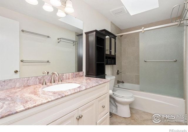 full bathroom featuring a skylight, vanity, tile patterned flooring, toilet, and tub / shower combination