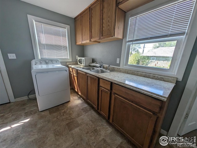 laundry room with washer / dryer, cabinet space, baseboards, and stone finish flooring