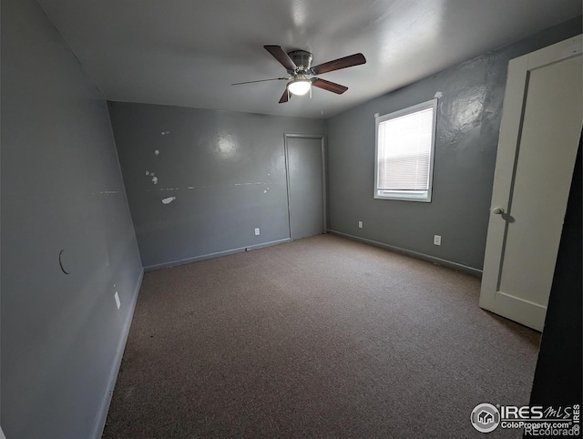 unfurnished bedroom with carpet floors, baseboards, and a ceiling fan