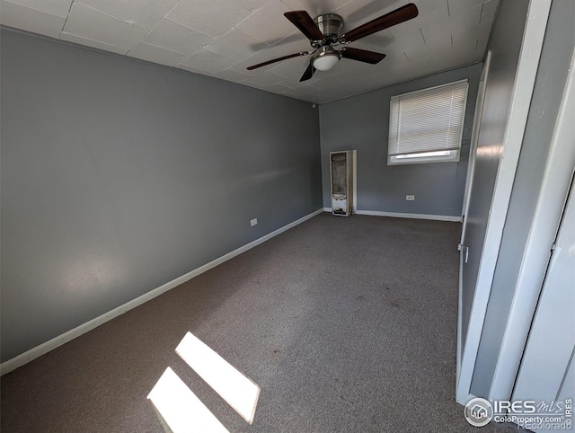 spare room featuring carpet floors, ceiling fan, and baseboards