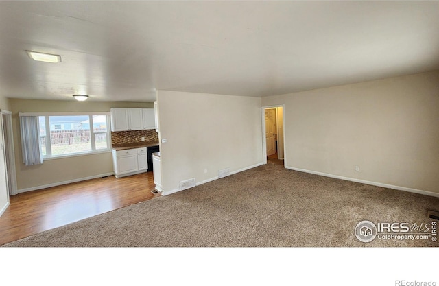214 Charmony Pl, Sterling, CO 80751 - unfurnished room with light carpet, baseboards, and light wood-style floors