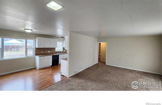 214 Charmony Pl, Sterling, CO 80751 - kitchen featuring black dishwasher, dark countertops, white cabinets, and baseboards