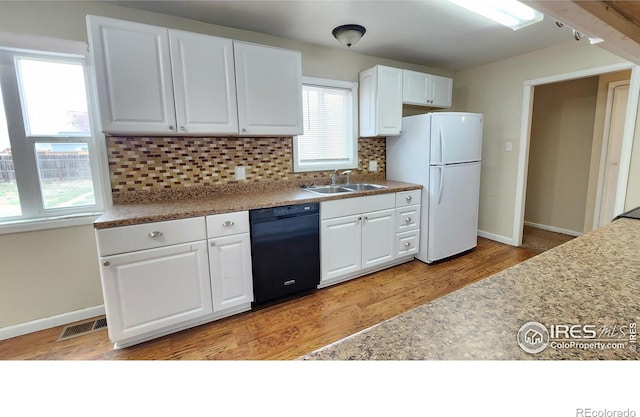214 Charmony Pl, Sterling, CO 80751 - kitchen with black dishwasher, a sink, freestanding refrigerator, and white cabinetry