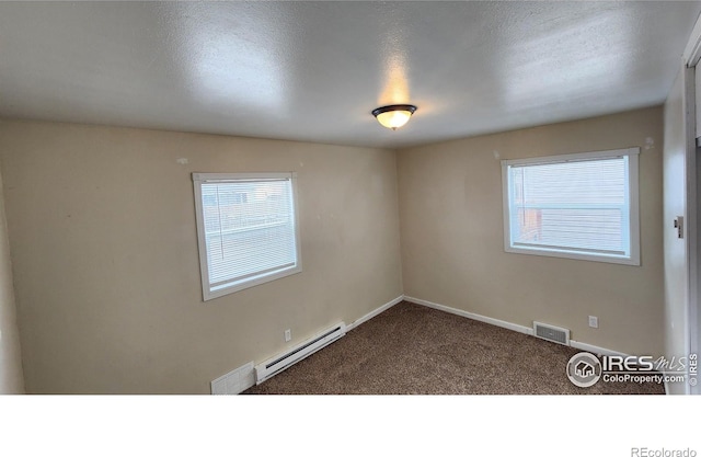 214 Charmony Pl, Sterling, CO 80751 - carpeted spare room featuring baseboard heating, healthy amount of natural light, baseboards, and a textured ceiling
