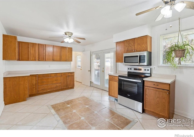 200 Perry St, Denver, CO 80219 - kitchen featuring appliances with stainless steel finishes, ceiling fan, healthy amount of natural light, and brown cabinets
