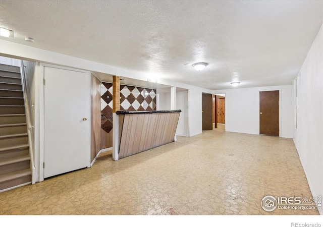 200 Perry St, Denver, CO 80219 - finished basement featuring stairway, tile patterned floors, and a textured ceiling