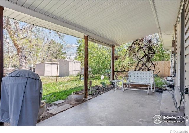 200 Perry St, Denver, CO 80219 - view of patio featuring area for grilling, a storage unit, fence, and an outbuilding