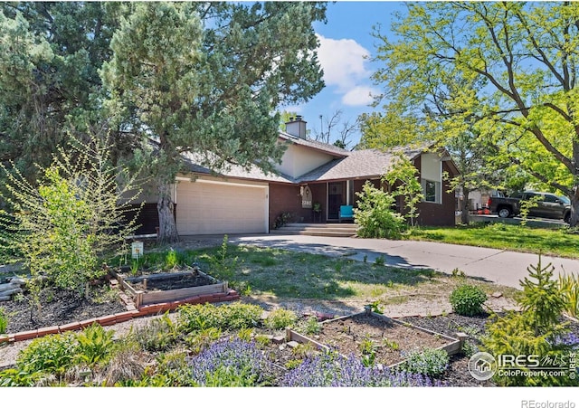 2702 W 23rd St, Greeley, CO 80634 - view of front of home featuring a garden, an attached garage, driveway, brick siding, and a front lawn