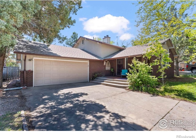 2702 W 23rd St, Greeley, CO 80634 - view of front of property featuring brick siding, an attached garage, driveway, a chimney, and roof with shingles