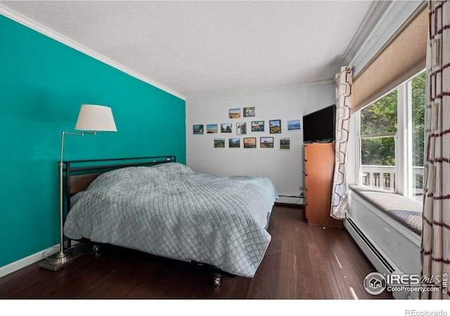 2702 W 23rd St, Greeley, CO 80634 - bedroom featuring a baseboard radiator, ornamental molding, wood finished floors, and a textured ceiling