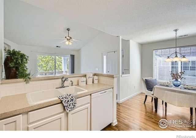 kitchen with dishwasher, a sink, light wood-style flooring, lofted ceiling, and ceiling fan