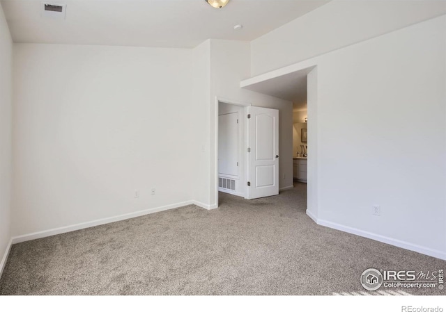 carpeted spare room featuring baseboards