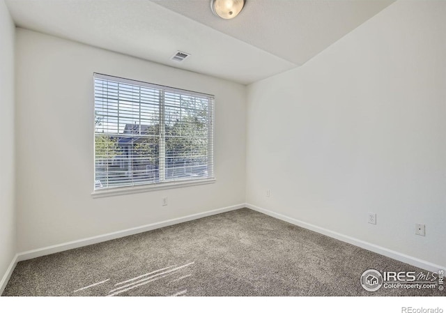 empty room featuring carpet and baseboards
