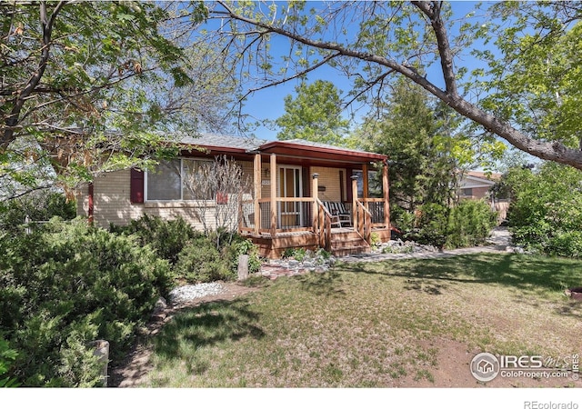 1207 S Tyler Ave, Loveland, CO 80537 - view of front of house featuring a porch and a front lawn