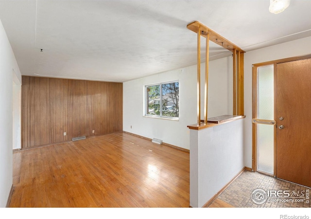 1207 S Tyler Ave, Loveland, CO 80537 - spare room with wood finished floors, wood walls, and baseboards