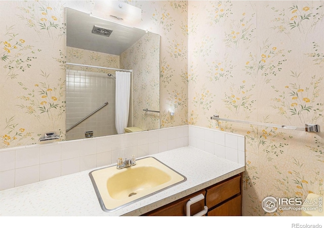 1207 S Tyler Ave, Loveland, CO 80537 - bathroom with wallpapered walls, vanity, and curtained shower