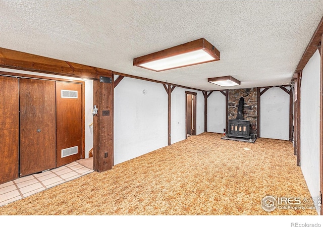 1207 S Tyler Ave, Loveland, CO 80537 - finished below grade area with a wood stove, a textured ceiling, and carpet