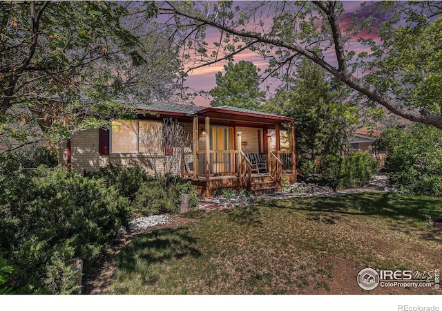 1207 S Tyler Ave, Loveland, CO 80537 - view of front facade with a porch and a front yard